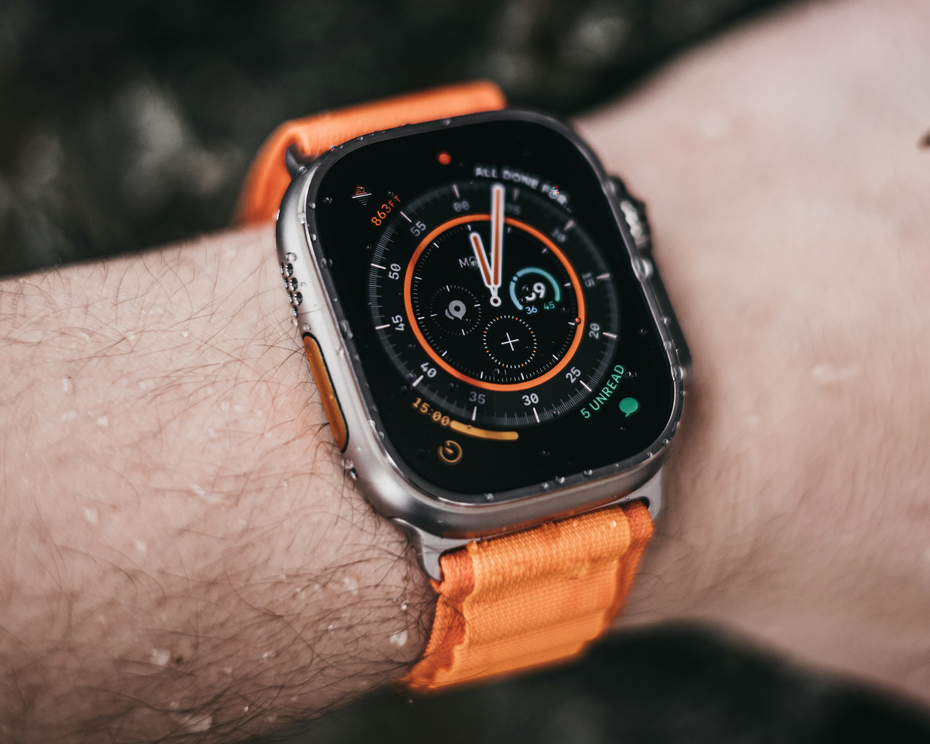 صورة حقيقية لساعة Apple Watch Ultra بسوار برتقالي على المعصم